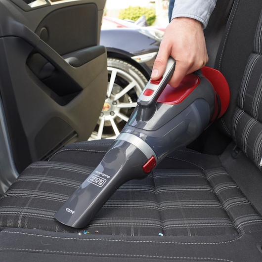 BLACKDECKER ADV1200 handheld vacuum cleaning car seat, photography showing device in use.