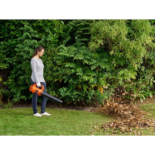 BLACKDECKER BCBL200L25 leaf blower used outdoors to clear leaves from grass.