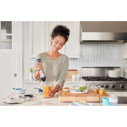 BLACKDECKER BCKM1011KGF hand blender used in modern kitchen with food prep ingredients on counter.