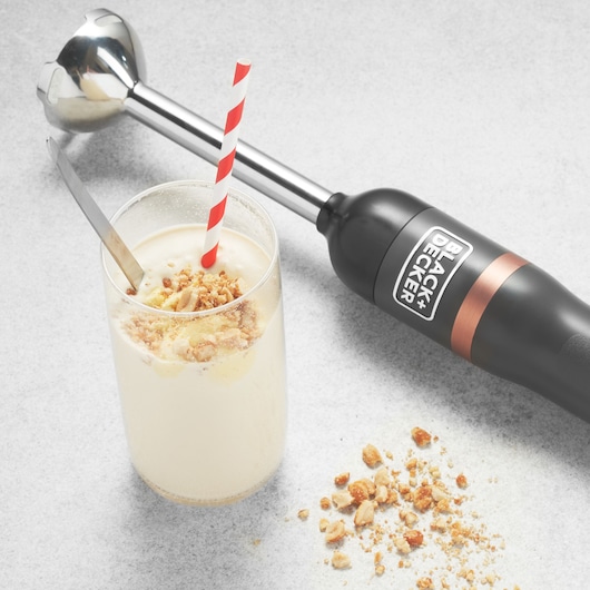 BLACKDECKER BCKM1011KGF hand blender on side angle with milkshake topped with nuts and a striped straw.