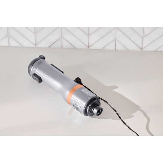 BLACKDECKER BCKM1011KGF handheld gray kitchen tool with orange accent, angled on countertop with cord visible.