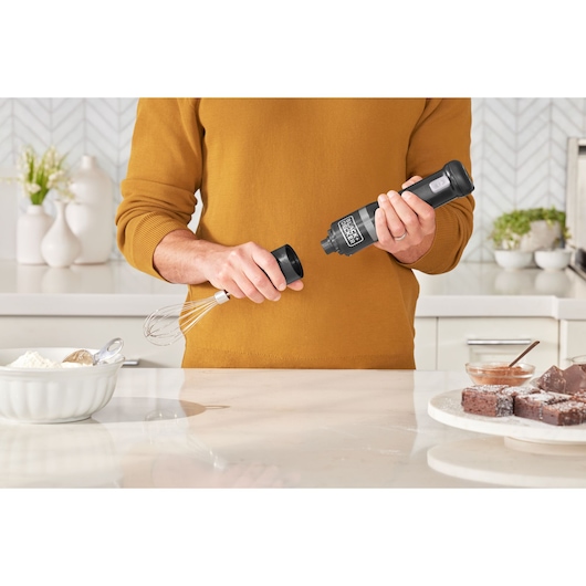 Photo of BLACKDECKER handheld mixer BCKM1012KB being assembled in a kitchen near baking ingredients.