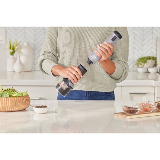 BLACKDECKER BCKM1012KG electric spice grinder in use on kitchen counter with salad and spices.