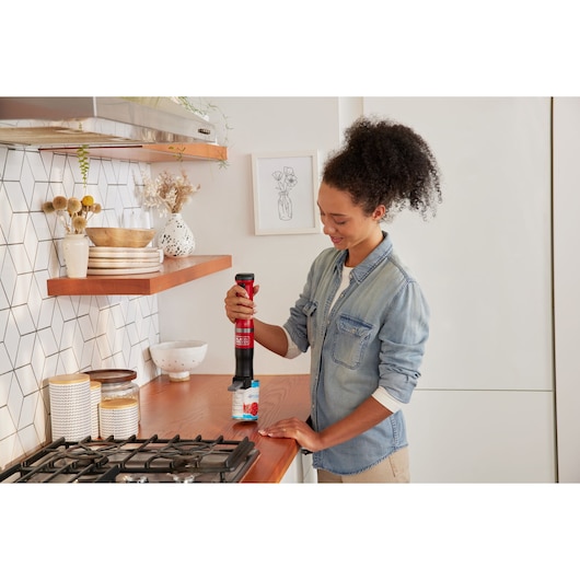 Photo of BLACKDECKER BCKM1012KR electric can opener in use on a kitchen counter.