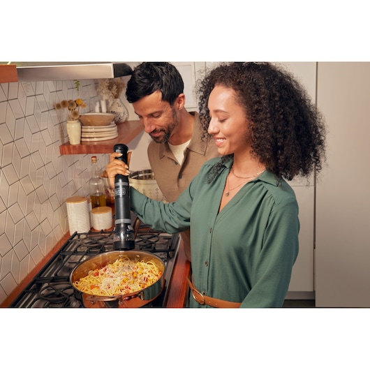 BLACKDECKER BCKM1016KSB immersion blender used to mix pasta in kitchen setting.