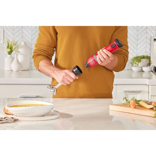 Photo of BLACKDECKER BCKM1016KSR red hand mixer in use in modern kitchen setting.
