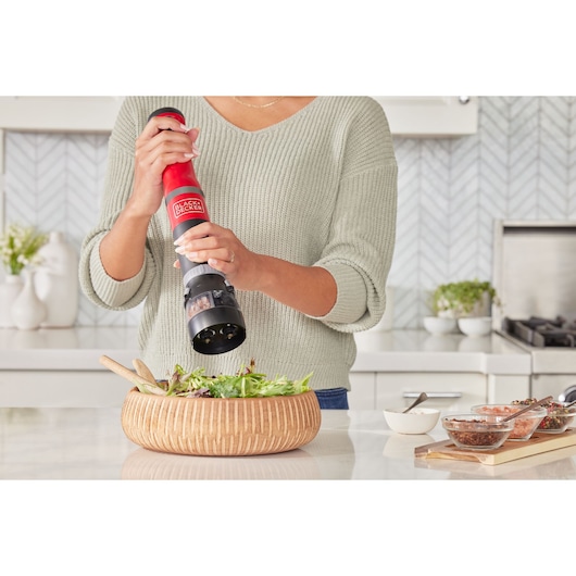 Photo of BLACKDECKER BCKM101SPFF electric pepper grinder being used over a salad bowl in a modern kitchen.