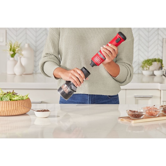 Photo of BLACKDECKER electric spice grinder BCKM101SPFF held in kitchen, red and black design.