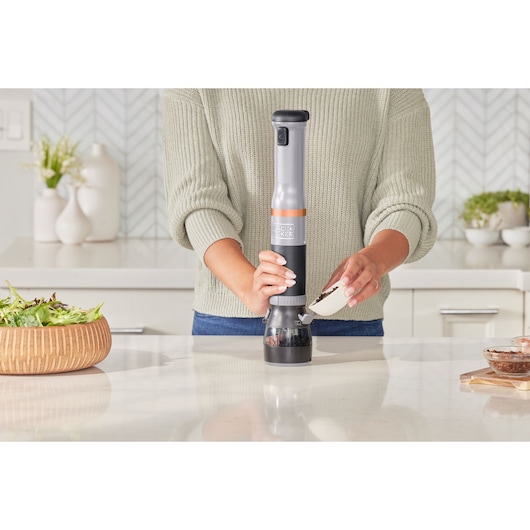 Photo of BLACKDECKER BCKM101SPFF kitchen appliance used on countertop, person pouring ingredients into it.