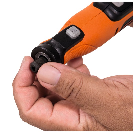 Close-up of a hand attaching a bit to the tip of an orange and black electric rotary tool.