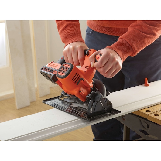 BLACKDECKER BDCCS18 cordless circular saw cutting wood, close-up of tool in use, orange and black design.