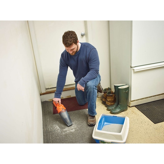 BLACKDECKER handheld vacuum BDCDB18N cleaning floor near boots and litter box in indoor setting.