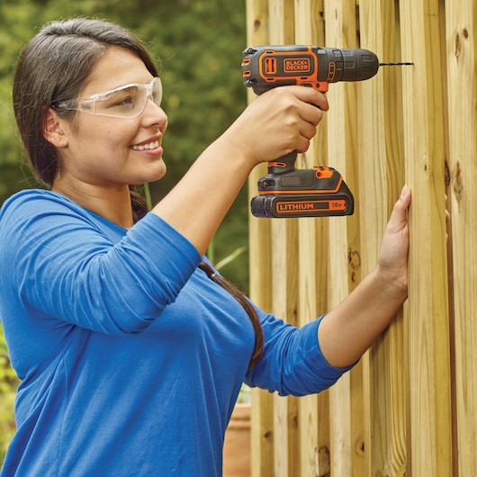 BLACKDECKER BDCDC18BAFC cordless drill in use on wooden planks, outdoors.