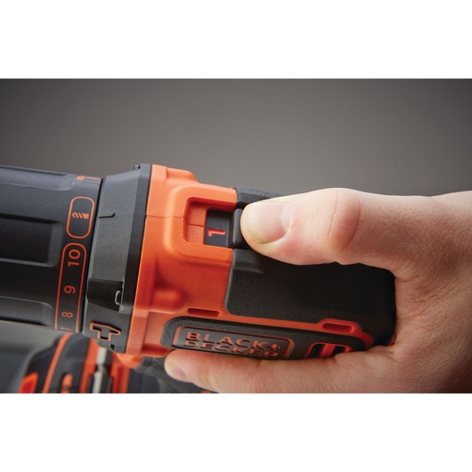Photo of BLACKDECKER BDCHD18KB2 cordless drill being adjusted by hand showing control switch detail.