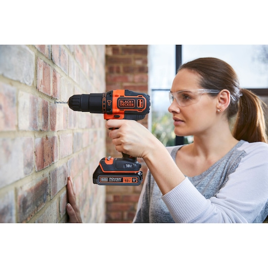Photo of BLACKDECKER BDCHD18KBST cordless drill being used on a brick wall.