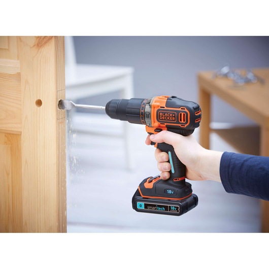 BLACKDECKER BDCHD18KST cordless drill in use drilling into wood door, 18V, close-up photography.