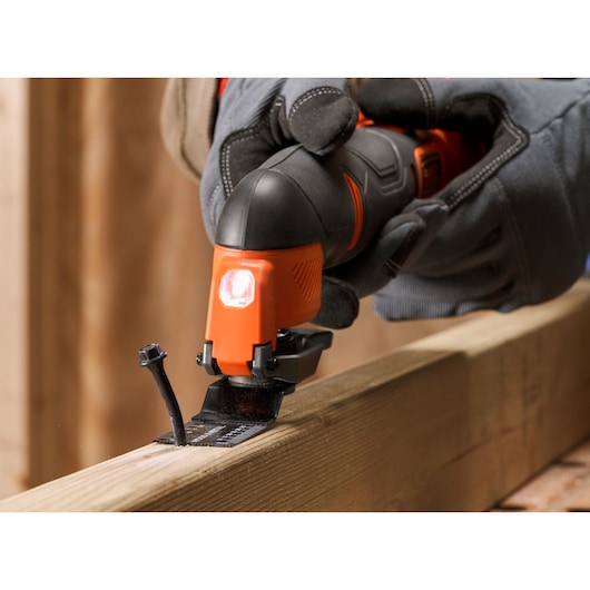 BLACKDECKER BDCOS18D1K oscillating tool cutting through wood plank, close-up photography.