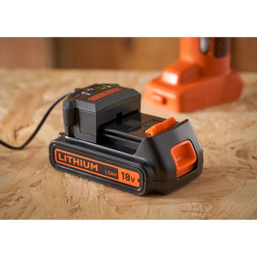 BLACKDECKER 18V 1.5Ah lithium battery charger BDCOS18D1K on wood surface, close-up angle.