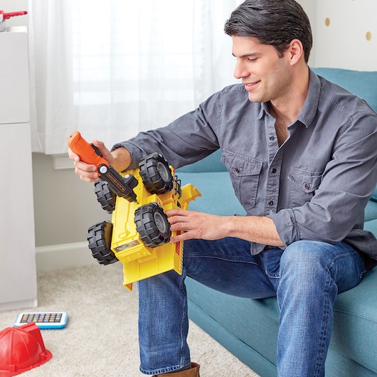 BLACKDECKER BDCSFL20AT orange cordless screwdriver used to fix toy truck indoors.