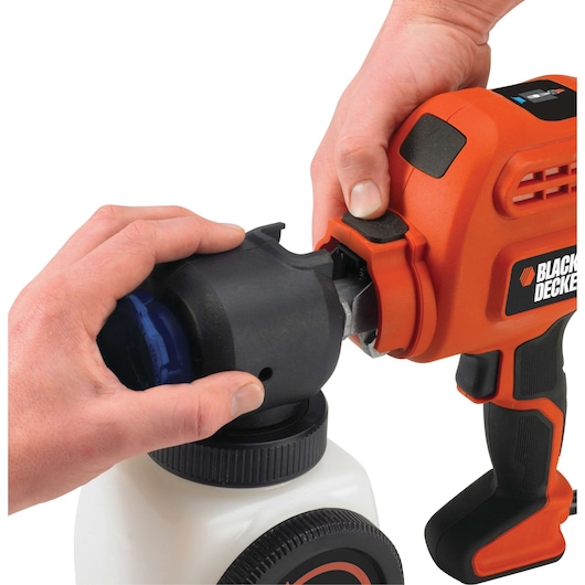 Photo of BLACKDECKER BDPS200 paint sprayer being assembled, close-up of hands attaching spray nozzle.