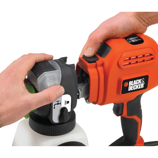 Photo of BLACK+DECKER BDPS400 paint sprayer close-up showing hands attaching the paint container to the tool, white background.