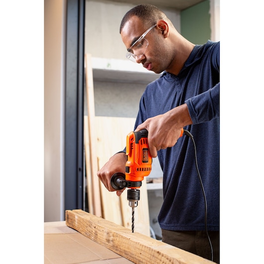Photo of BLACK+DECKER BEH640 corded electric drill with side handle being used on wood.