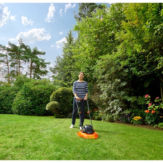 BLACKDECKER BEMWH551 lawn mower with handle, orange and black, used outdoors on green grass.