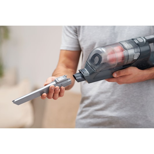 BLACKDECKER BHFEA18D1 cordless vacuum cleaner with crevice tool attachment held by person indoors.
