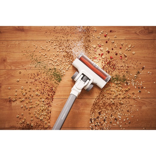 BLACKDECKER BHFEA515J stick vacuum cleaning assorted debris from wooden floor, top view.