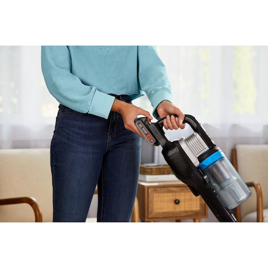 BLACKDECKER BHFEB520D1 cordless stick vacuum held by person indoors, close-up view.