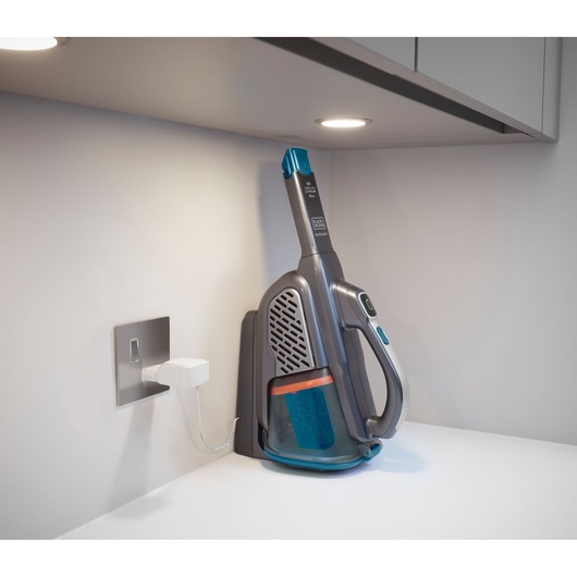 BLACKDECKER BHHV520BF cordless handheld vacuum on charging dock, side angle, with blue and gray design.