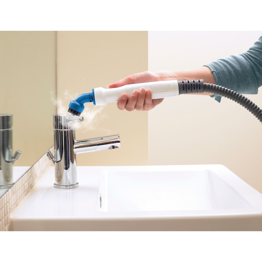 BLACKDECKER BHSM1615DSG steam cleaner nozzle used on bathroom faucet, close-up photo.
