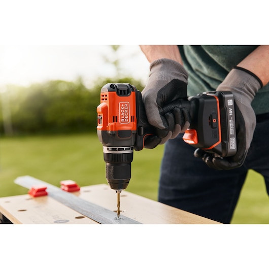 BLACKDECKER cordless drill BLD682XN in use drilling metal outdoors, close-up view.