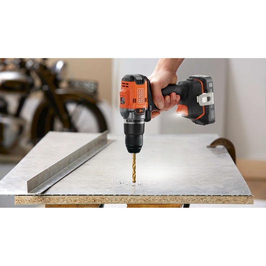 BLACKDECKER cordless drill BLD683D1 drilling into metal sheet, close-up photography.