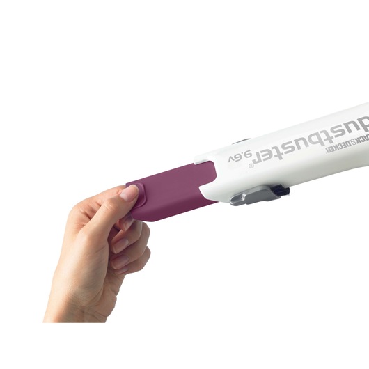Photo of a hand attaching a purple nozzle to a WHITE BLACK+DECKER hand vacuum DV9610ECN, side angle.