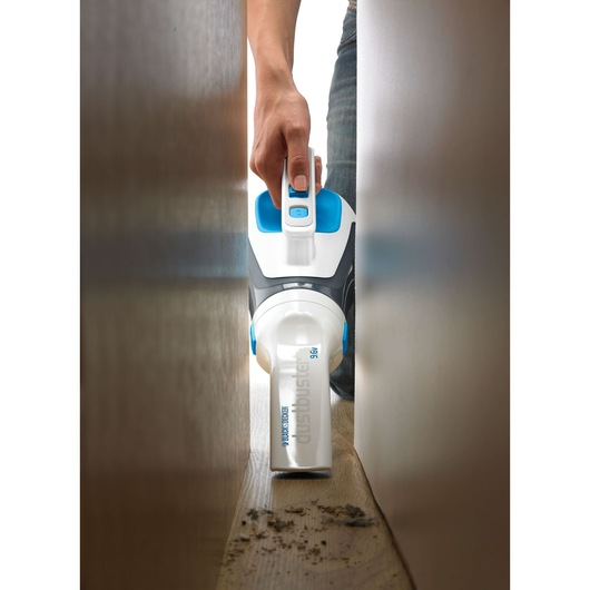 BLACKDECKER DV9610N handheld vacuum cleaning dust in narrow space, close-up photography.