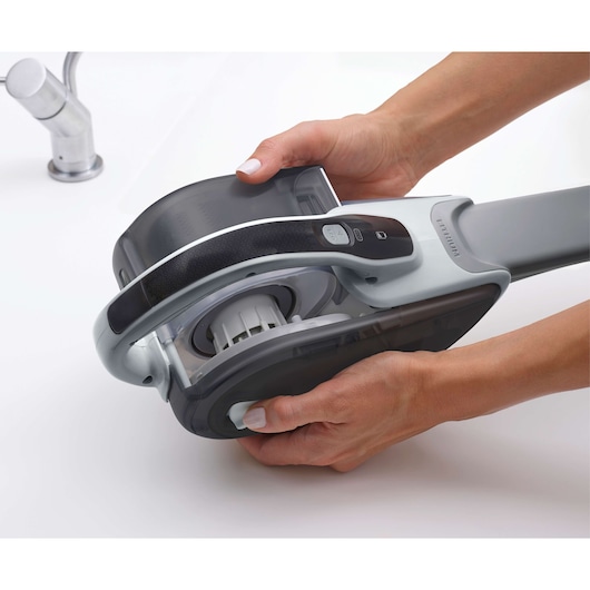 BLACKDECKER DVJ215J handheld vacuum, close-up photography showing dust container removal.