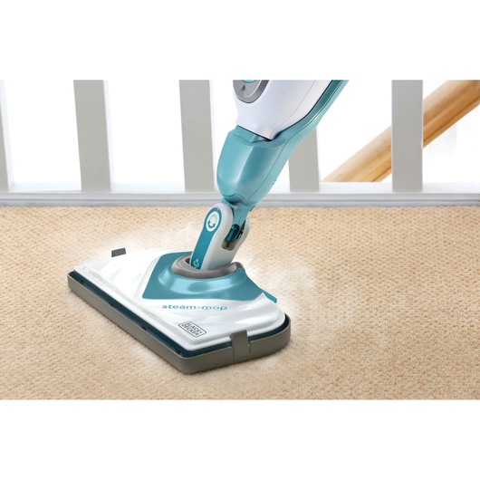 BLACKDECKER FSMCG steam mop cleaning beige carpet, photo from above showing mop head and handle.