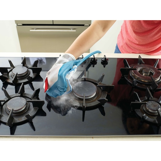 BLACK+DECKER FSMH13101SM steam glove cleaning stovetop on kitchen counter, photo from above.