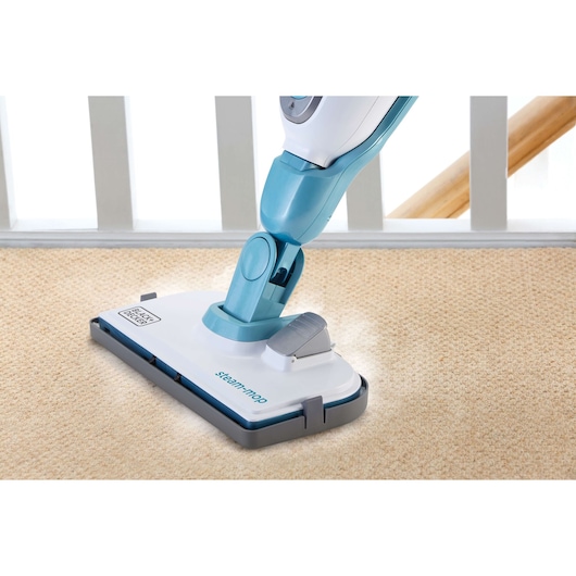 BLACK+DECKER FSMH13101SM steam mop cleaning beige carpet, side angle, blue and white body.