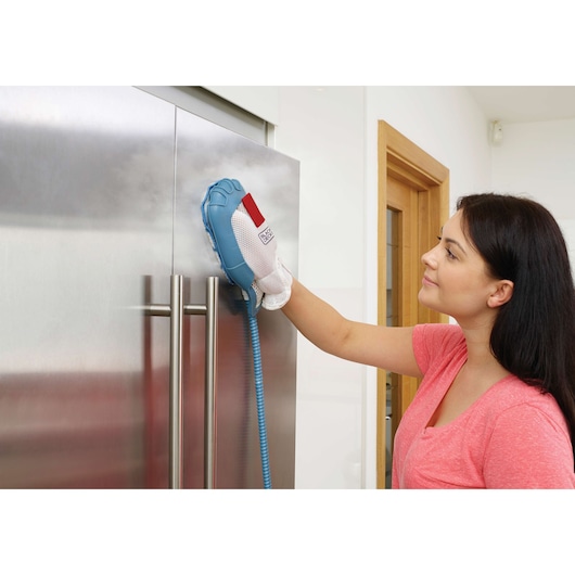 BLACKDECKER FSMH13101SM steam cleaning glove in use on stainless steel fridge door.