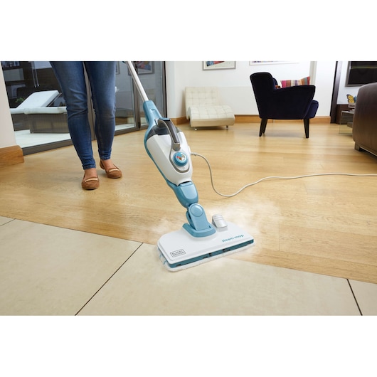 BLACKDECKER FSMH13101SM steam mop cleaning light wood and tile floor in home living room, front angle