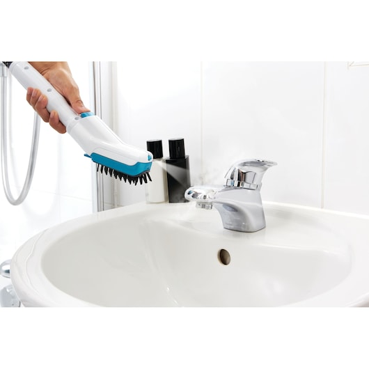 BLACKDECKER FSMH13101SM steam cleaner brush attachment cleaning a bathroom sink faucet.