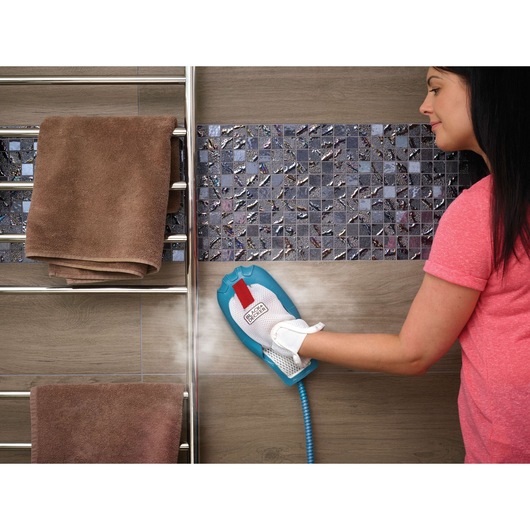 BLACKDECKER FSMH13151SM steam cleaning glove in use on bathroom wall tiles, brown towels visible.