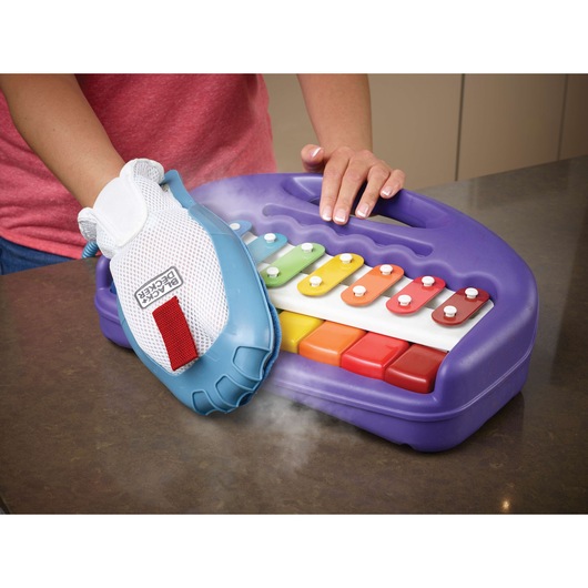 BLACKDECKER FSMH13151SM steam glove cleaning a purple toy xylophone with colorful keys on a countertop