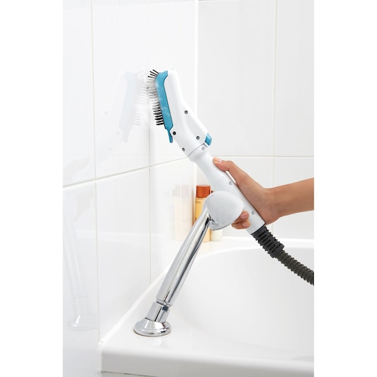 BLACKDECKER FSMH13151SM steam cleaner with brush attachment cleaning white bathroom tiles, handheld view.