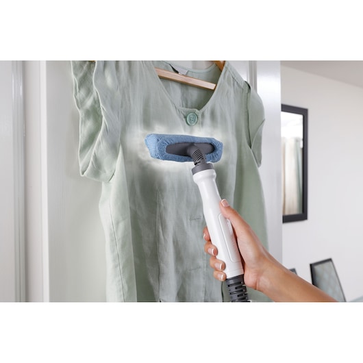 BLACK+DECKER FSMH1321 steam cleaner on green shirt, handheld mode, product demonstration.