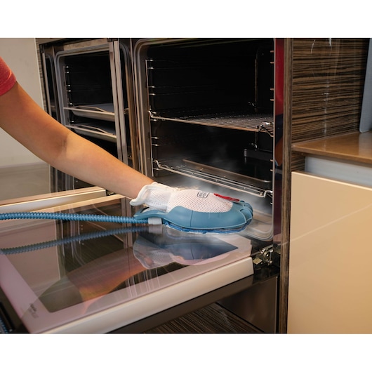 BLACKDECKER FSMH1351SM steam cleaning mitt in use on oven door interior, product action.