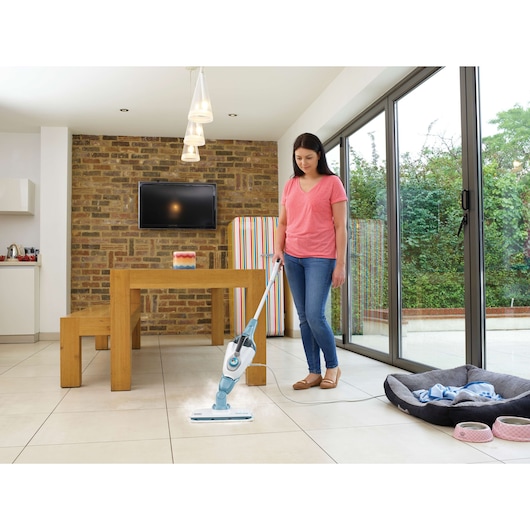 BLACKDECKER FSMH1351SM steam mop cleaning white tile floor in modern kitchen, person holding handle.
