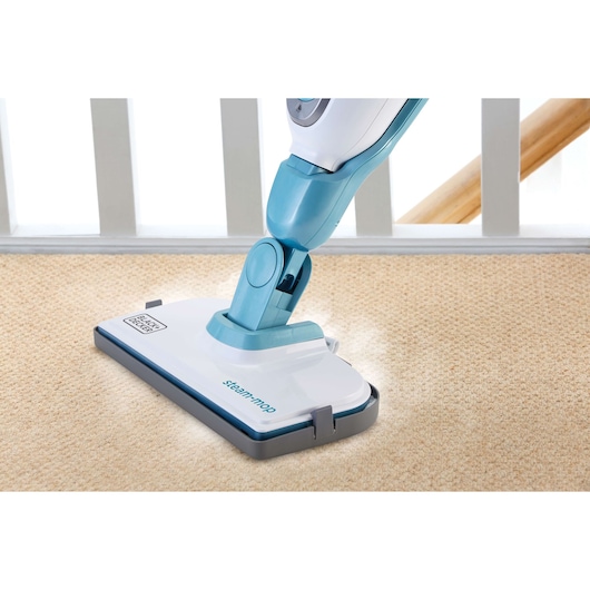 Photo of BLACKDECKER FSMH1351SM steam mop cleaning beige carpet, top-down angle.
